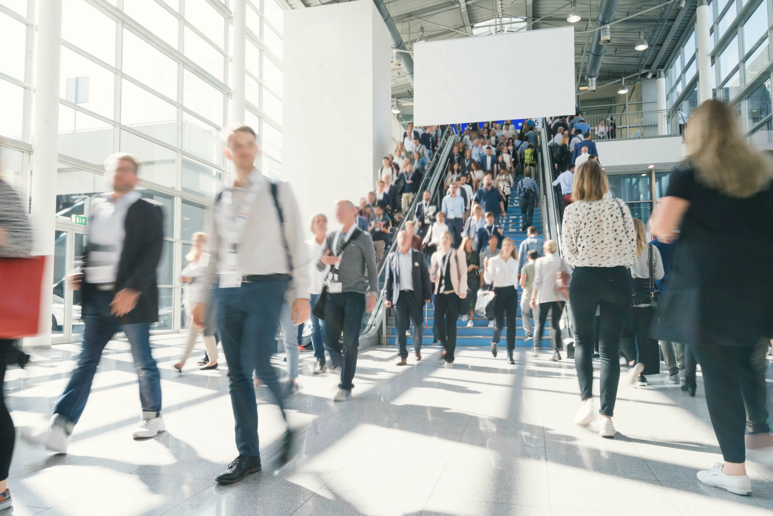 Messebesucher in einer Messehalle als Symbol für Messeshuttle und Eventlogistik